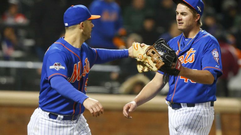 New York Mets third baseman David Wright (5) gives teammate New York Mets relief pitcher Addison Reed (43) the glove tap after the seventh inning during Game 2 of the NLCS against the Chicago Cubs at Citi Field on Sunday, Oct. 18, 2015.