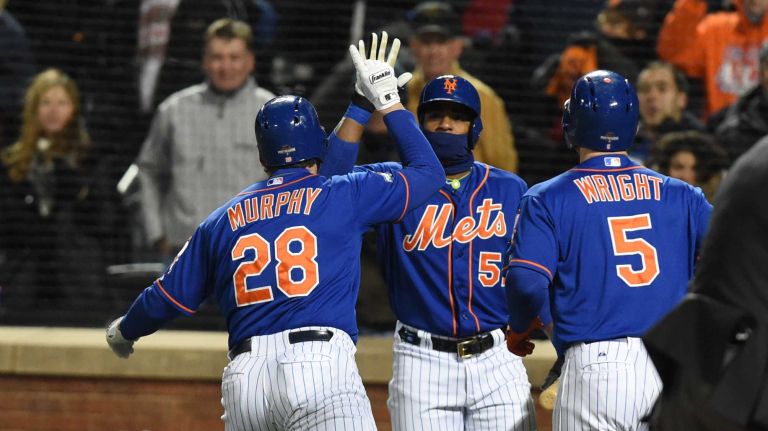 New York Mets second baseman Daniel Murphy (28) is greeted at home by teammates after his 2 run homerun in first inning during Game 2 of the NLCS against the Chicago Cubs at Citi Field on Sunday, Oct. 18, 2015.