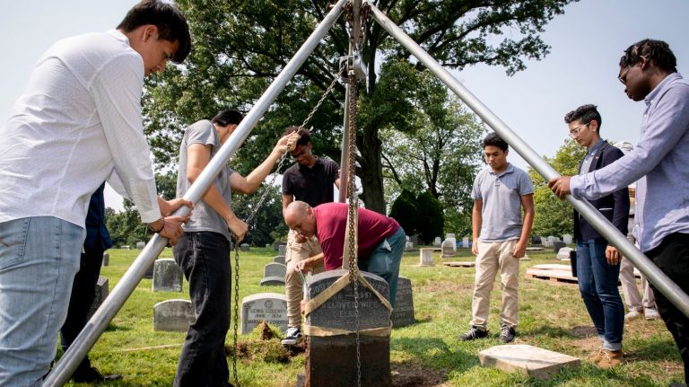 Brooklyn high school students reset a monument in a public lot at Green-Wood Cemetery on Thursday. 