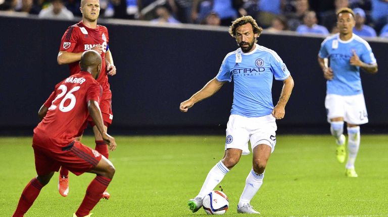 New York City FC midfielder Andrea Pirlo is defended by Toronto FC midfielder Collen Warner in an MLS game at Yankee Stadium on Wednesday, Sept. 16, 2015.