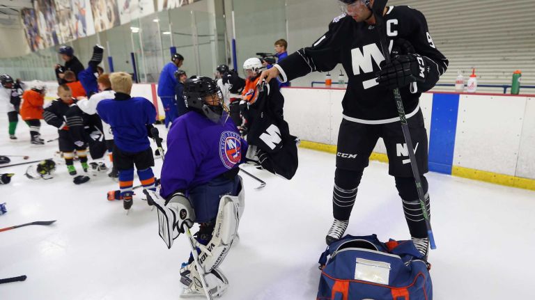 John Tavares #91 of the New York Islanders hands out the team's third uniform to youth hockey players during a skate on Sept. 15, 2015 at Iceworks in Syosset.
