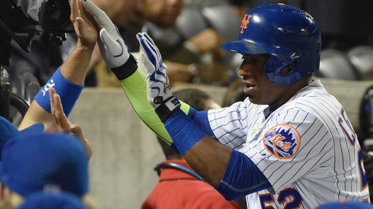 New York Mets leftfielder Yoenis Cespedes is congratulated in the dugout after his solo home run against the Miami Marlins during the third inning of a game at Citi Field on Monday, Sept. 14, 2015.