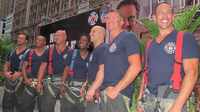 New York's Bravest gather around fellow firefighter-- and the first Ms. March-- Danae Mines of Engine Co. 60 in Times Square on July 15, 2014.