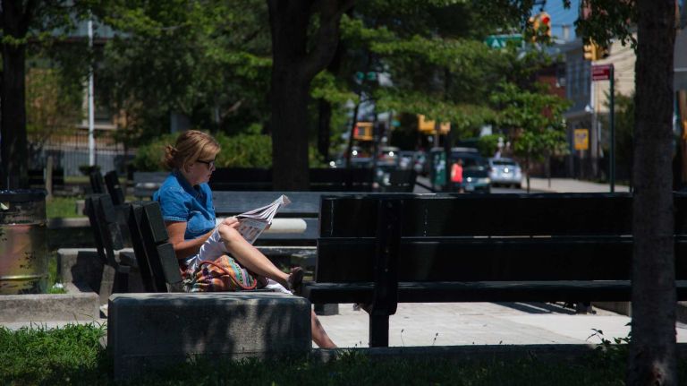 College Point, Queens 25 Maureen Mahonry 60 spending her lunch break reading the news paper on a park bench on College Point Boulevard by 14 Ave.City Living in the neighborhood of College Point in Queens.August 7, 2015