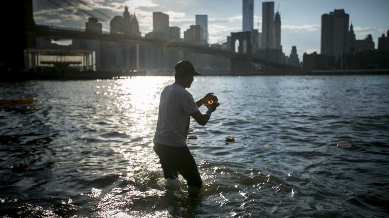 Ketan Patel, of Gujarat, India, places candles in the East River during a Hindu Candle Lighting Ceremony in Brooklyn Bridge Park in Brooklyn, NY, on August 1, 2015.