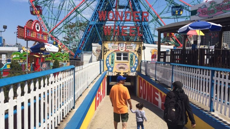 Visitors to Deno's Wonder Wheel Amusement Park walk down a ramp on May 25, 2015, leading from the kiddie rides to the pleasure wheel that has made the park famous. 