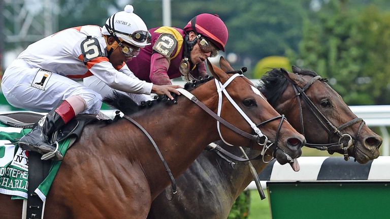 Race horses No. 2 March and No. 5 Cinco Charlie fight for the lead in the third race at Belmont Park in Elmont on the afternoon of the Belmont Stakes on June 6, 2015. No. 2 March won the race.