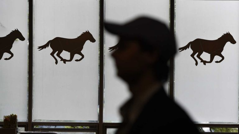 A fan passes a window at Belmont Park on Saturday morning before the 147th running of the Belmont Stakes on June 6, 2015, in Elmont.
