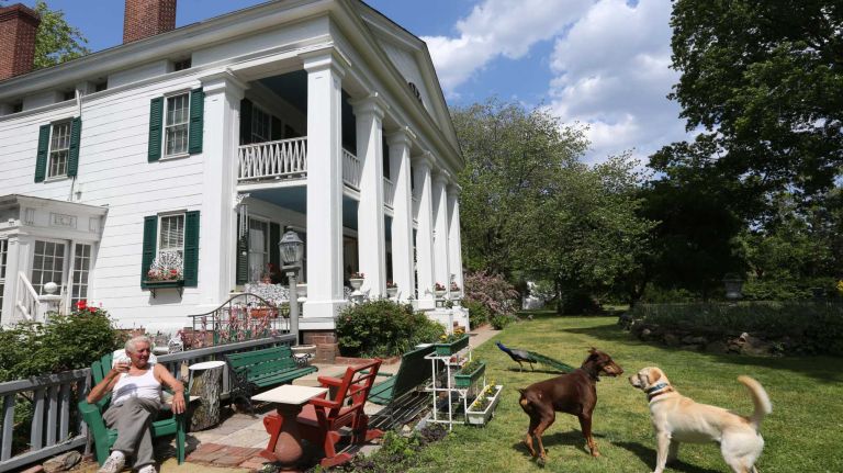 George Burke, 85, relaxes on the lawn of the Seguine Mansion, which he owns, in Prince's Bay, Staten Island, Friday, May 22, 2015.
