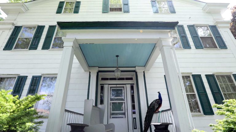 A peacock on the front porch of the Seguine Mansion in Prince's Bay, Staten Island, Friday, May 22, 2015.