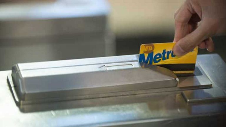 A subway rider swipes a MetroCard at a turnstile.