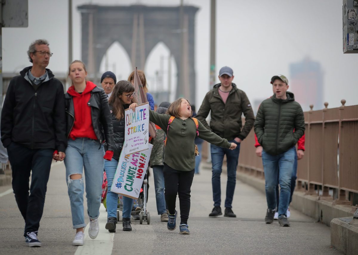 Climate change activist Zayne Cowie walks on the Brooklyn Bridge during a youth climate march in New York
