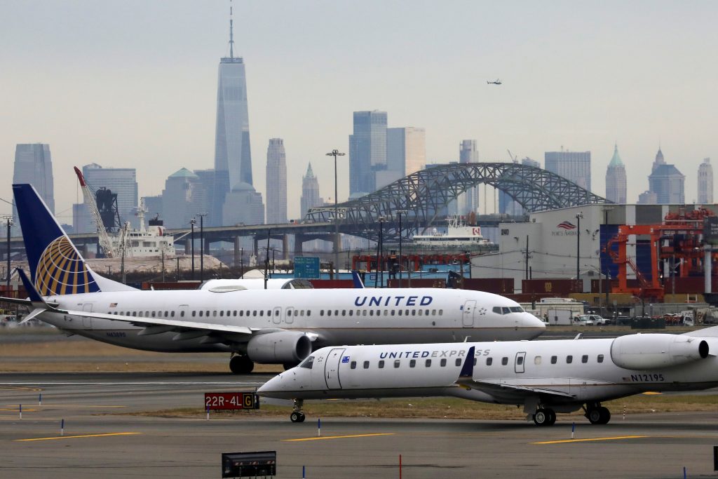 United Airlines passenger jets taxi with New York City as a backdrop
