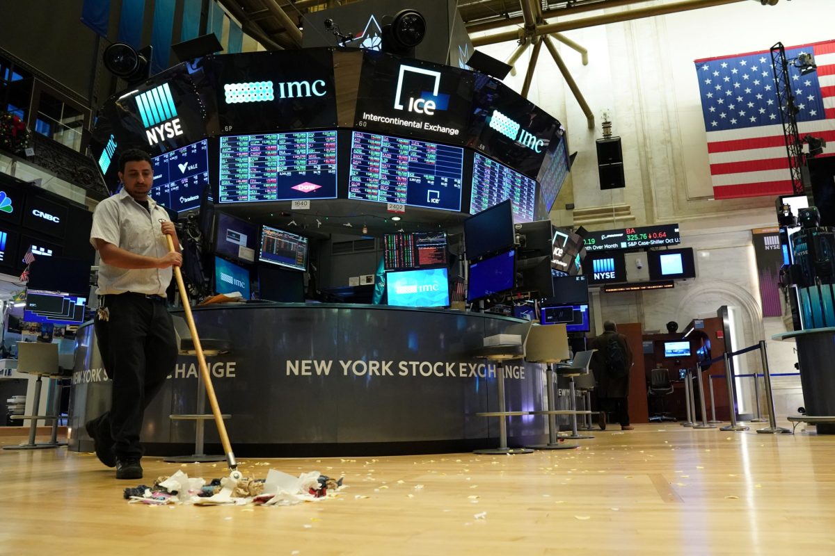 A maintenance worker sweeps the floor at the New York Stock Exchange
