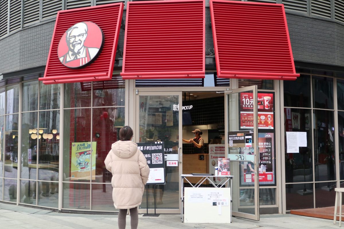 Customer waits to pick up her order outside a KFC restaurant as the country is hit by an outbreak of the novel coronavirus, in Chengdu
