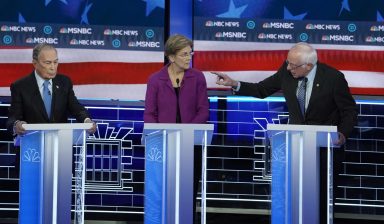 Bernie Sanders speaks to Michael Bloomberg about the non-disclosure agreements at Bloomberg’s company as Senator Elizabeth Warren listens at the ninth Democratic 2020 U.S. Presidential candidates debate at the Paris Theater in Las Vegas