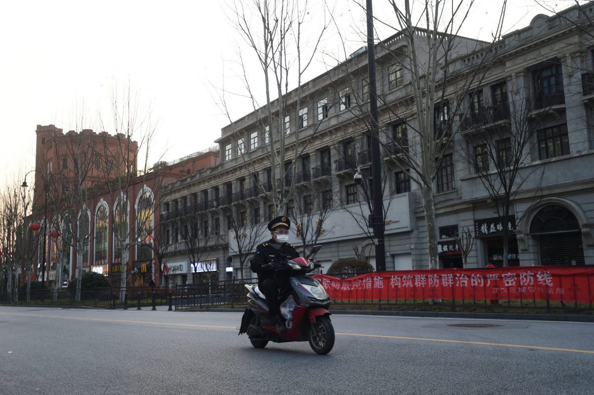 FILE PHOTO:  Man wearing a face mask rides a bike on a main avenue in Wuhan, the epicentre of the novel coronavirus outbreak