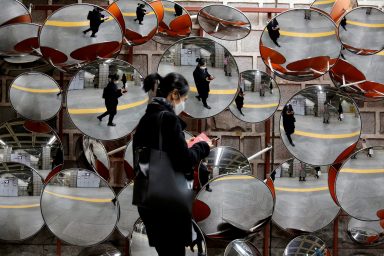 FILE PHOTO: Woman wearing a mask to prevent the coronavirus is reflected on the mirrors, in Seoul