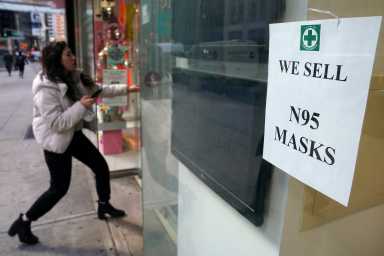 A woman walks into a pharmacy to purchase N95 face masks in advance of the potential coronavirus outbreak in the Manhattan borough of New York City