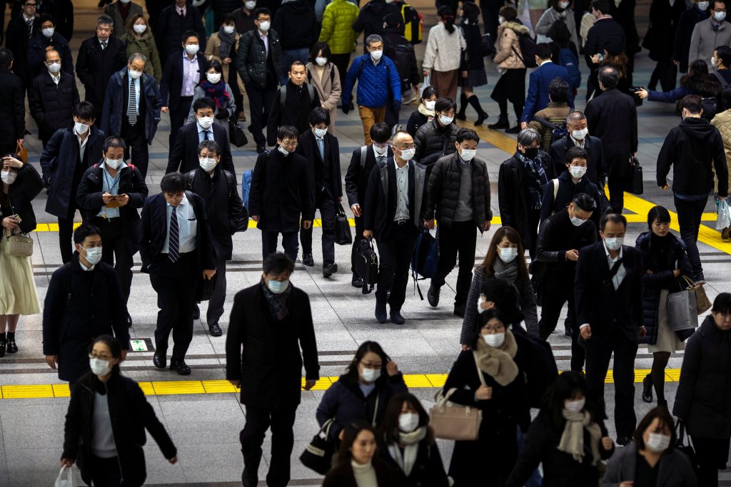 People wearing protective face masks, following an outbreak of the coronavirus, are seen at the Shinagawa station in Tokyo