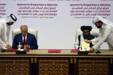 Mullah Abdul Ghani Baradar, the leader of the Taliban delegation, signs an agreement with Zalmay Khalilzad, U.S. envoy for peace in Afghanistan, at a signing agreement ceremony between members of Afghanistan’s Taliban and the U.S. in Doha