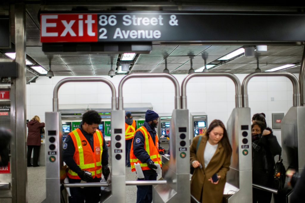 FILE PHOTO: People enter the subway station as MTA worker disinfects the station in the Manhattan borough of New York City, New York