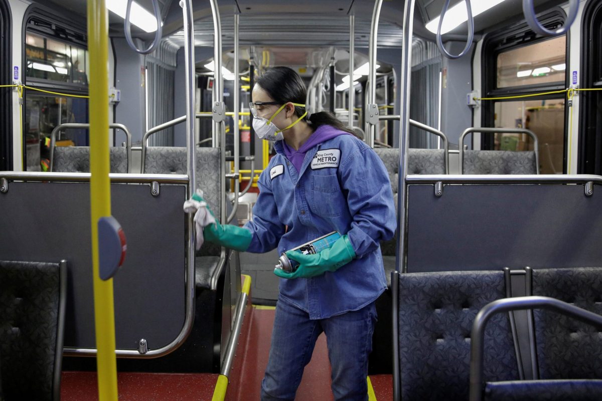 FILE PHOTO: Vehicle Maintenance Utility Service Worker Thiphavanh ‘Loui’ Thepvongsa wipes down an off-duty bus with a disinfectant during a routine cleaning at the King County Metro Atlantic and Central Base in Seattle