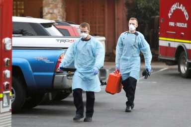Emergency medical personnel walk out of the Life Care Center of Kirkland, the Seattle-area nursing home at the epicenter of one of the biggest coronavirus outbreaks in the United States, after moving a patient to an ambulance in Kirkland, Washi