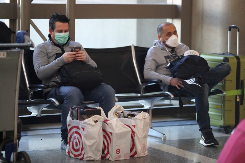 FILE PHOTO: People wear masks at the international terminal at LAX airport in Los Angeles