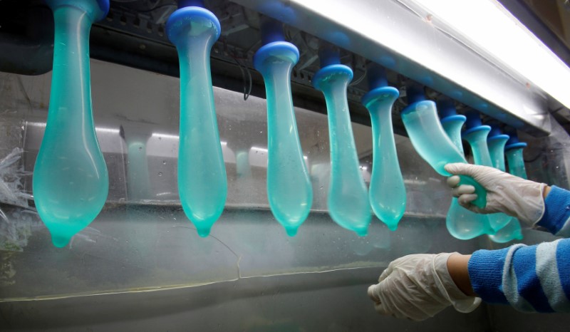 FILE PHOTO: A worker performs a test on condoms at Malaysia’s Karex condom factory in Pontian