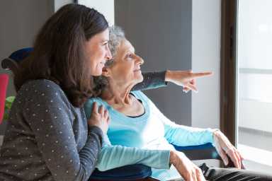 Happy senior mother and adult daughter enjoying dramatic view
