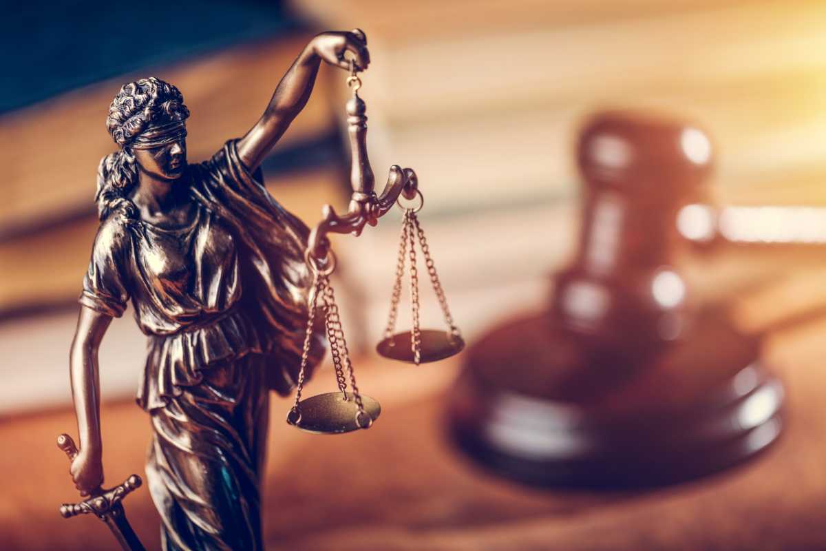 Law concept – Themis statue, judge hammer and books.