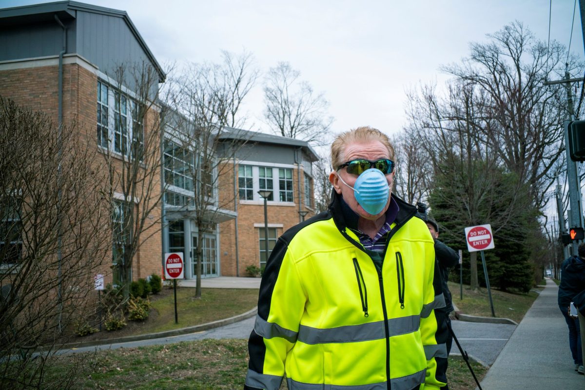 A man wears a face mask as he walks in front of Young Israel orthodox synagogue in New Rochelle, New York