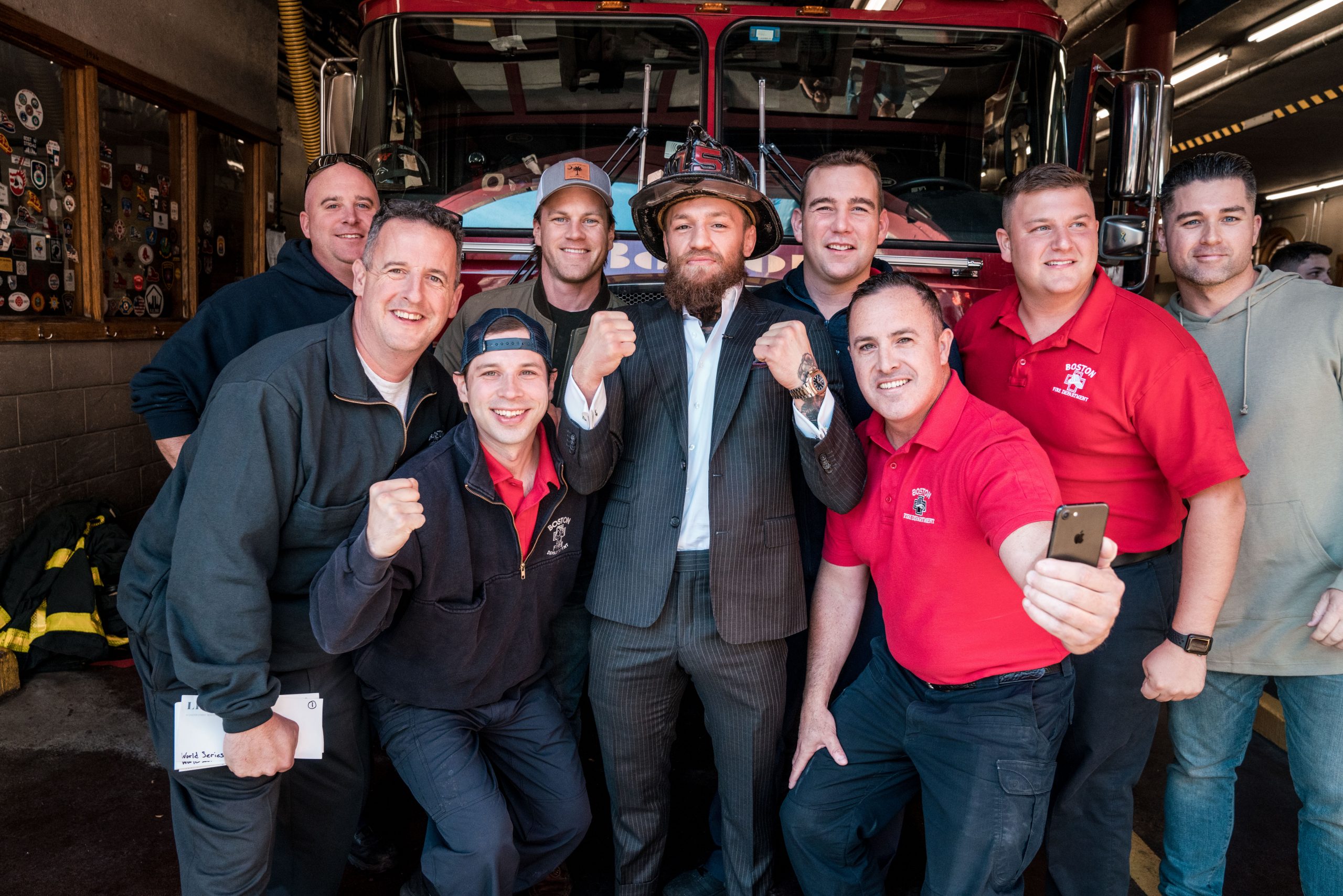 Conor McGregor poses with firefighters in a station house