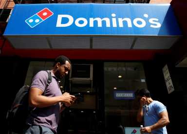 People pass by a Domino’s Pizza restaurant in New York