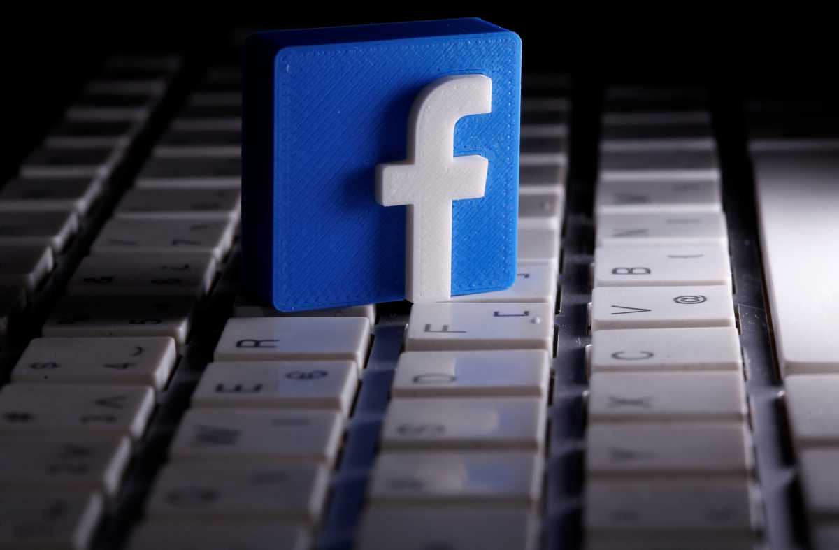 A 3D-printed Facebook logo is seen placed on a keyboard in this illustration