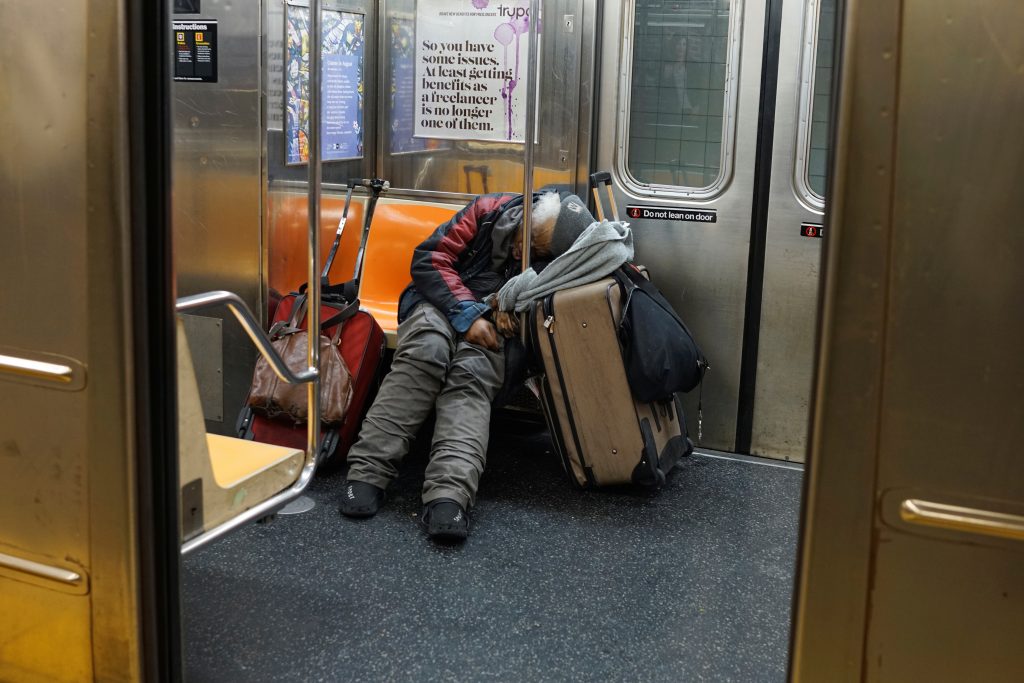 A man sleeps on a New York subway train as the outbreak of the coronavirus disease (COVID-19) continues in the subways of New York