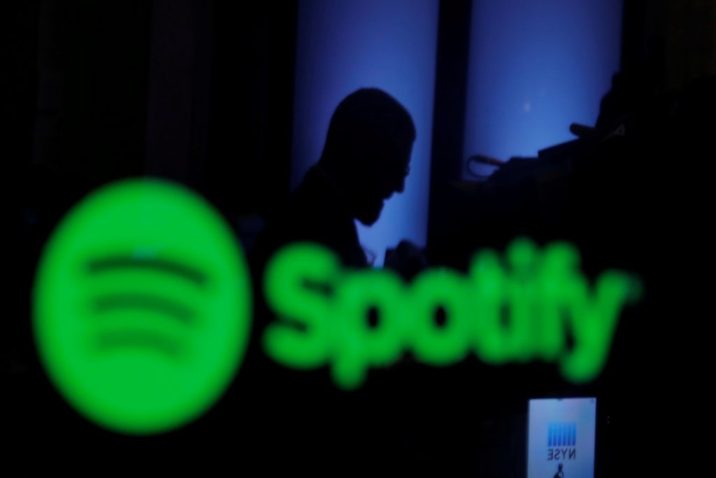 FILE PHOTO: A trader is reflected in a computer screen displaying the Spotify brand before the company begins selling as a direct listing on the floor of the New York Stock Exchange in New York