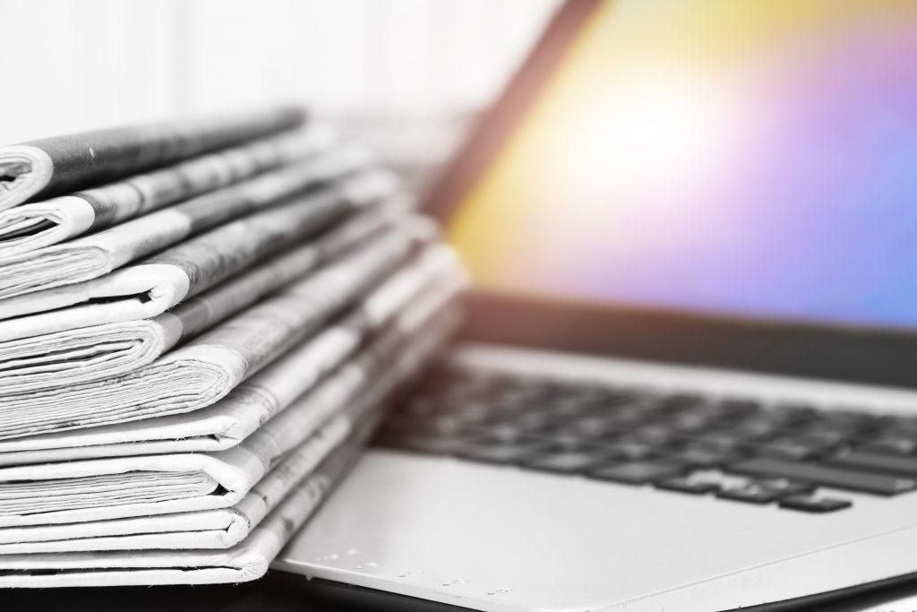 Newspapers and Open Laptop
