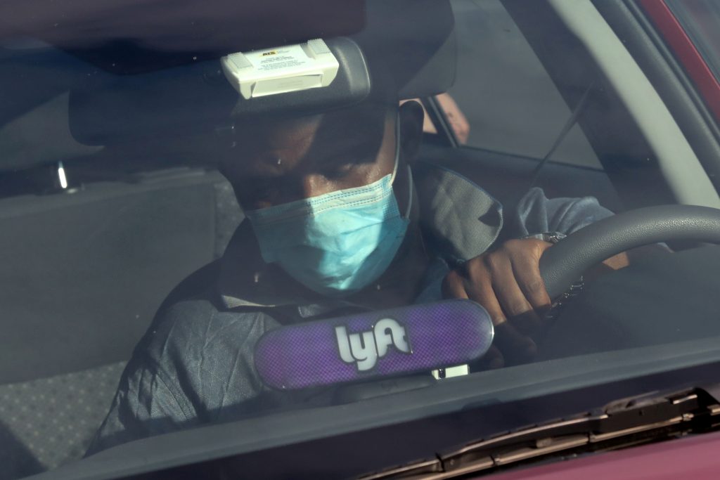 FILE PHOTO: A Lyft rideshare driver wears a mask as he leaves passengers in the U.S. Capitol Hill neighborhood in Washington