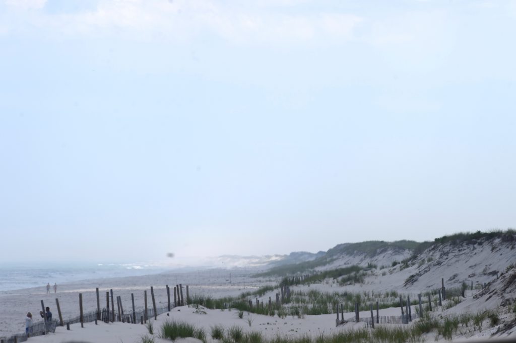 FILE PHOTO: Beach goers walk by the ocean in Seaside Park, New Jersey