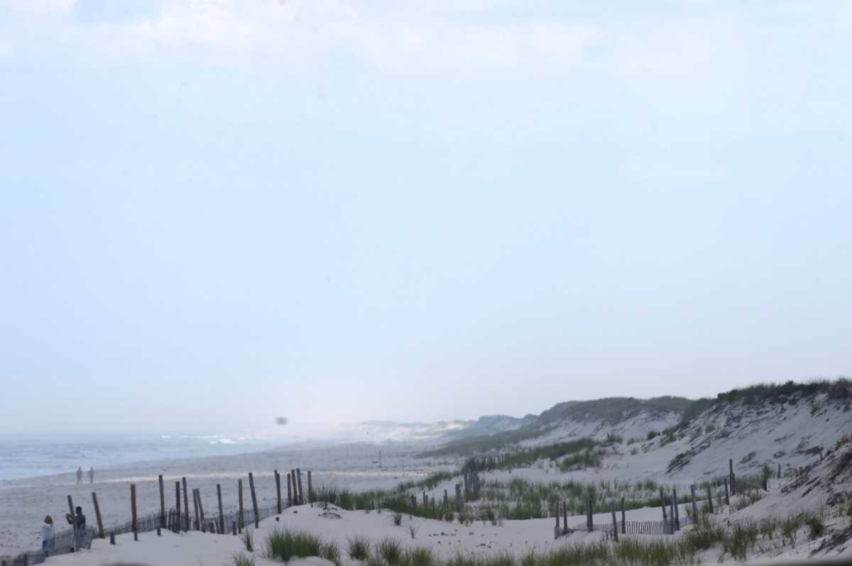 FILE PHOTO: Beach goers walk by the ocean in Seaside Park, New Jersey