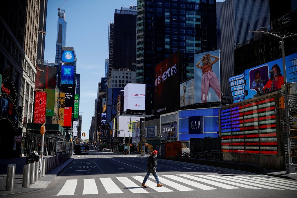 FILE PHOTO: A man crosses 7th Avenue in nearly deserted Times Square during the outbreak of the coronavirus disease (COVID-19) in New York