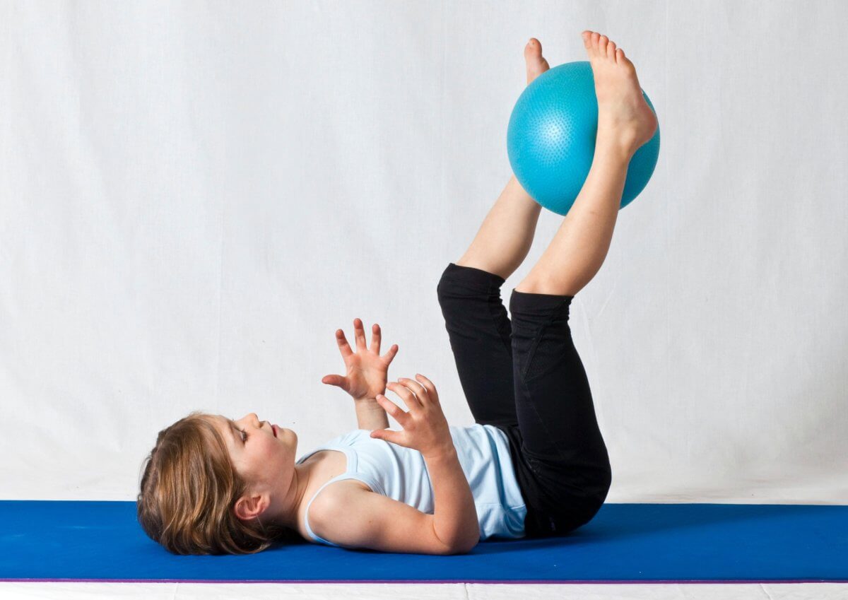 girl-in-white-shirt-and-black-pants-lying-on-blue-exercise-3992594-1200×849