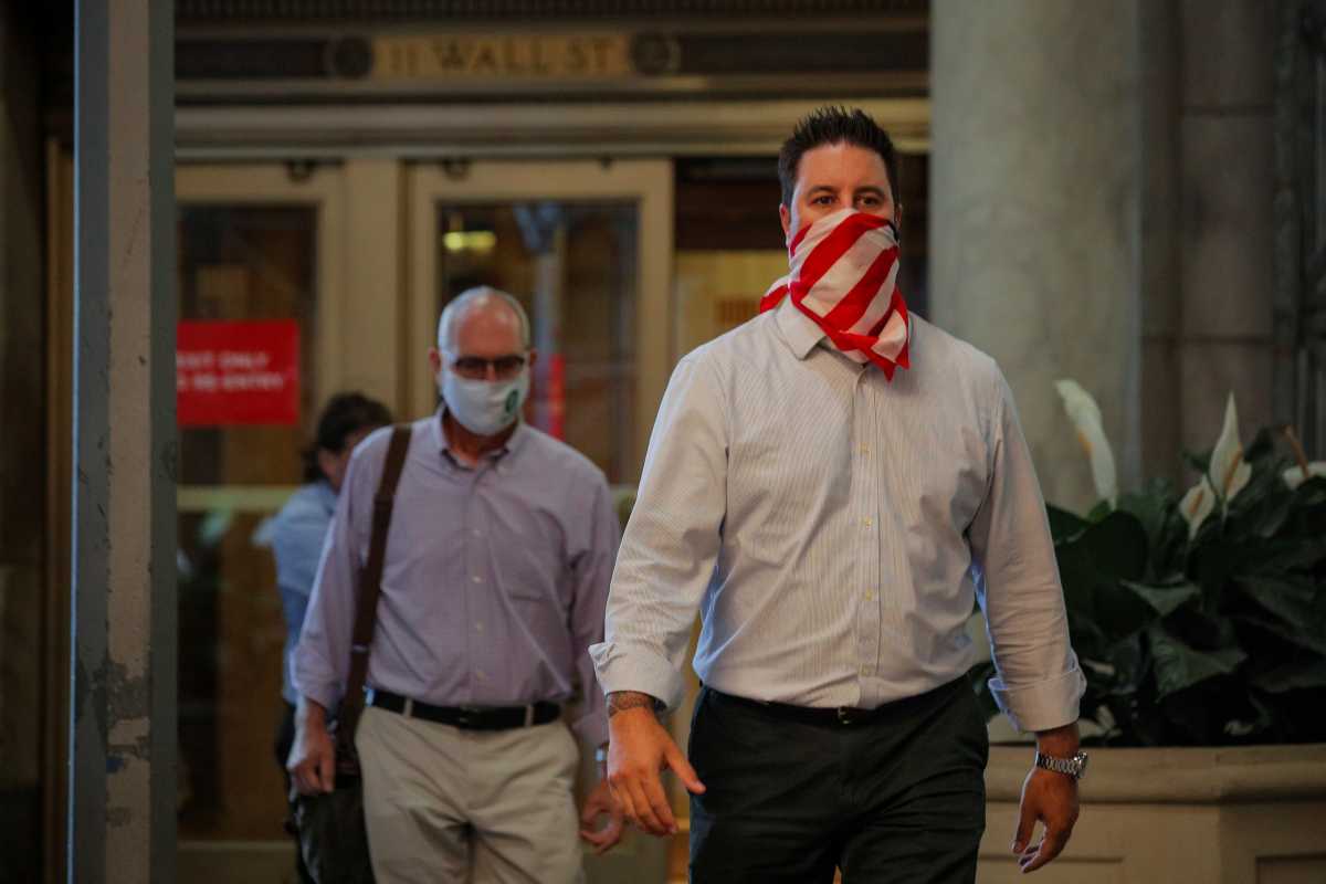 Traders exit the 11 Wall St. door of the NYSE in New York
