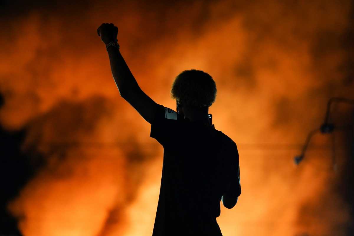 A protester watches as a Wendy’s burns following a rally against racial inequality and the police shooting death of Rayshard Brooks, in Atlanta