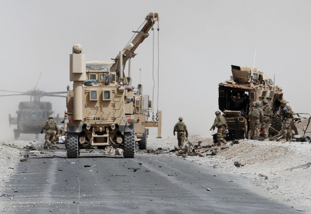 FILE PHOTO: U.S. troops assess the damage to an armored vehicle of NATO-led military coalition after a suicide attack in Kandahar province