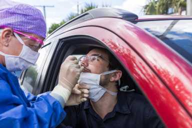 A doctor taking a nasal swab from a driver