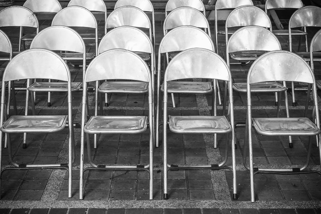Rows of iron chairs are set up for an outdoor performance