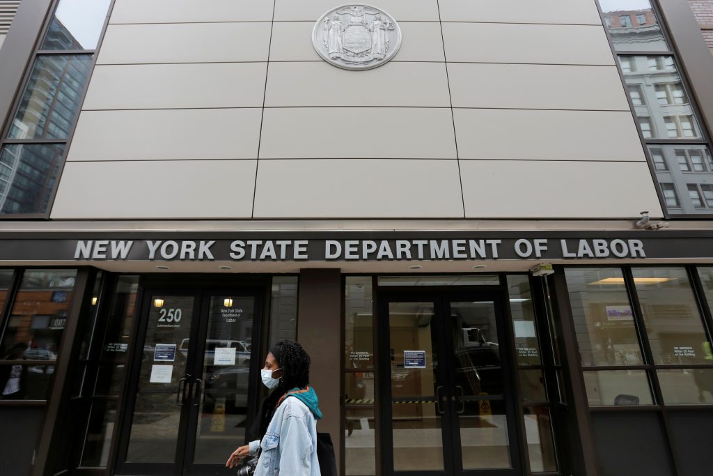 A person walks by the entrance of the New York State Department of Labor offices, which closed to the public due to the coronavirus disease (COVID-19) outbreak in the Brooklyn borough of New York City